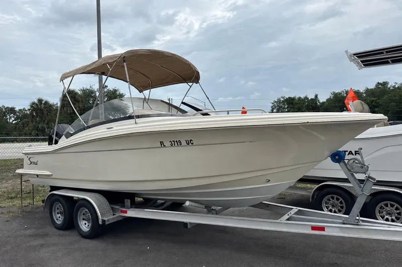 The Image of 2023 Scout 215 Dorado boat on trailer with canopy, parked outdoors. - 0