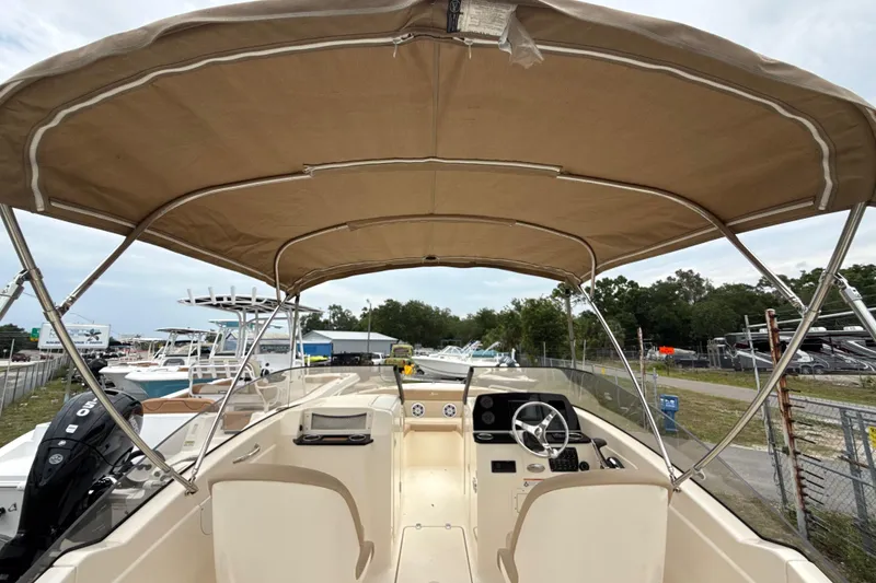 Slide: The Image of 2023 Scout 215 Dorado boat interior with canopy, steering wheel, and control panel. - 19