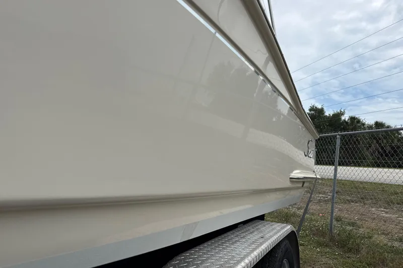 Slide: The Image of 2023 Scout 215 Dorado boat side view with trailer, outdoors. - 2