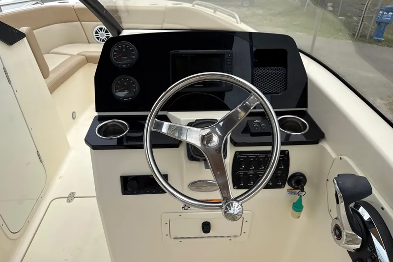 Slide: The Image of 2023 Scout 215 Dorado boat dashboard with steering wheel and control panel. - 22