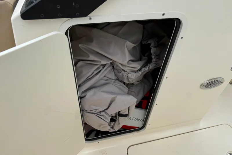 Slide: The Image of Storage compartment on 2023 Scout 215 Dorado boat, containing a folded cover and equipment. - 33
