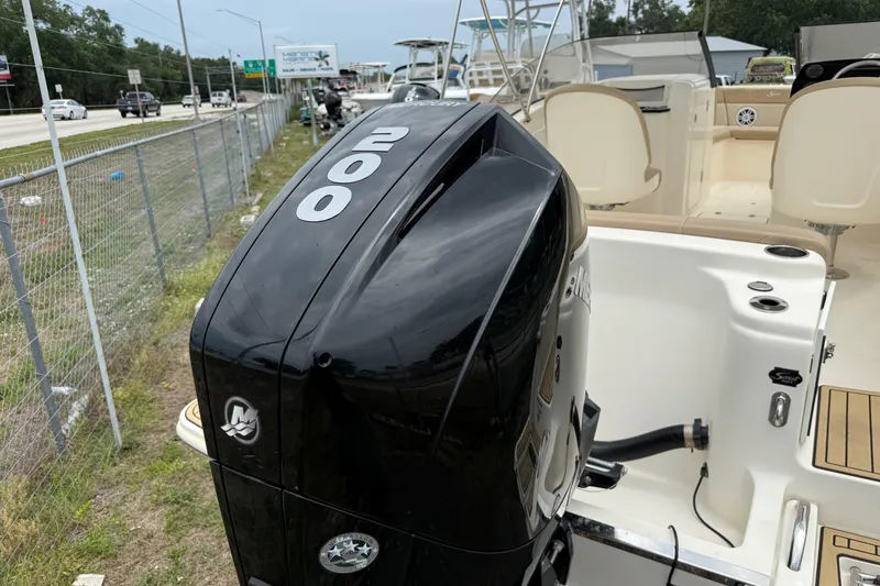Slide: The Image of 2023 Scout 215 Dorado boat with a 200 horsepower engine, parked near a road. - 38