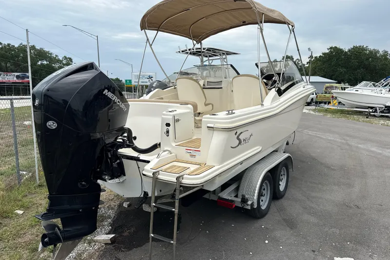 Slide: The Image of 2023 Scout 215 Dorado boat with Mercury engine on trailer, parked outdoors. - 4