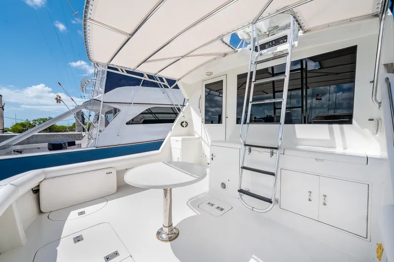 Slide: The Image of 1992 Hatteras 50 Convertible yacht deck with seating, table, and ladder. - 17
