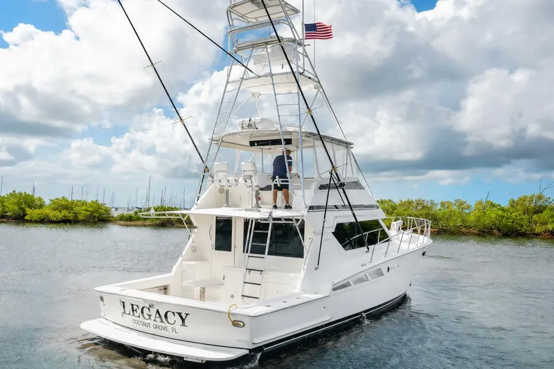 Slide: The Image of 1992 Hatteras 50 Convertible yacht cruising in scenic waters under a cloudy sky. - 61