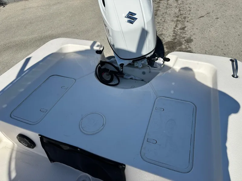 Slide: The Image of 2025 Carolina Skiff Sea Skiff 218 EV boat deck with motor and storage compartments. - 12