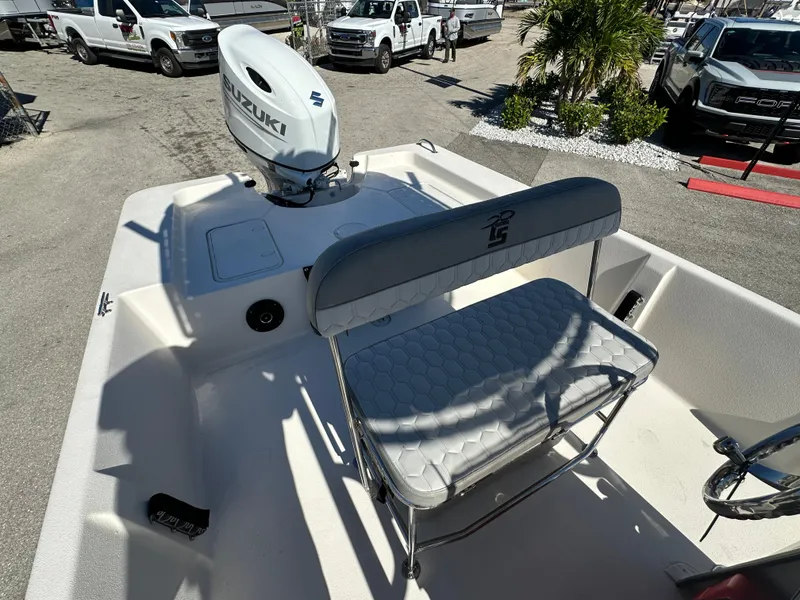 Slide: The Image of 2025 Carolina Skiff Sea Skiff 218 EV boat with Suzuki outboard motor, parked outdoors. - 24