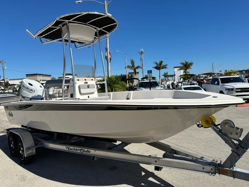 Slide: The Image of 2025 Carolina Skiff Sea Skiff 218 EV on trailer, sunny day, palm trees in background. - 6