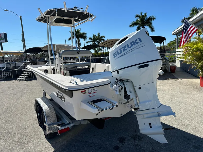 Slide: The Image of 2025 Carolina Skiff Sea Skiff 218 EV with Suzuki outboard motor, parked outdoors. - 9