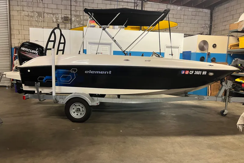 The Image of 2019 Bayliner Element E18 boat on trailer in garage setting. - 0