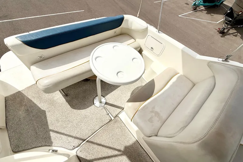 Slide: The Image of 1999 Sea Ray Sundancer 260 boat interior with seating and round table. - 10