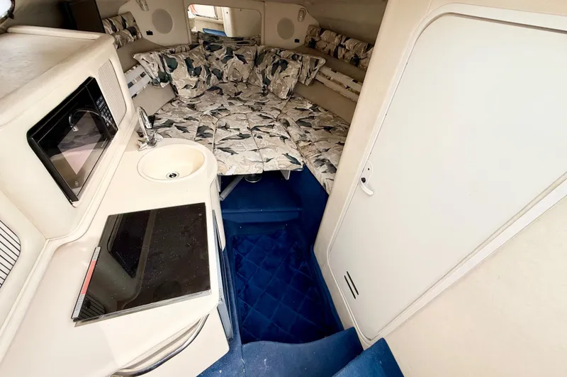 Slide: The Image of Interior of 1999 Sea Ray Sundancer 260 with kitchenette and cozy sleeping area. - 15