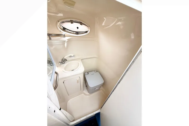 Slide: The Image of Compact bathroom in 1999 Sea Ray Sundancer 260 boat, featuring sink and portable toilet. - 20