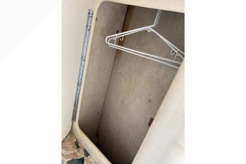 Slide: The Image of Empty closet with hangers inside a 1999 Sea Ray Sundancer 260 boat. - 21
