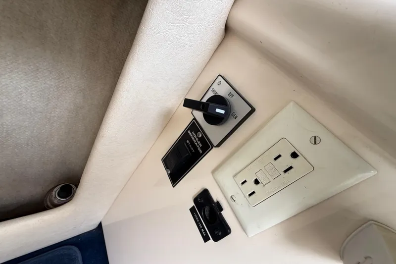Slide: The Image of 1999 Sea Ray Sundancer 260 interior control panel with power outlet and switches. - 23
