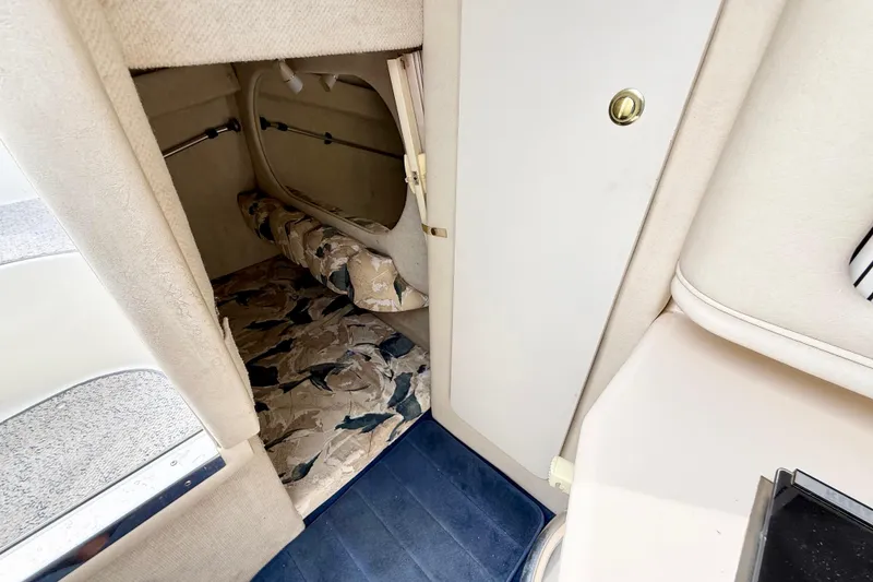 Slide: The Image of Interior cabin of 1999 Sea Ray Sundancer 260 with patterned upholstery and blue carpet. - 26