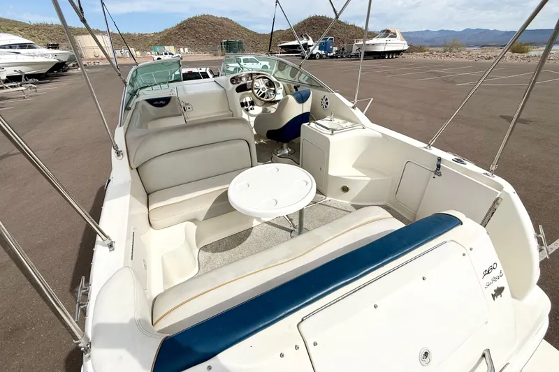 Slide: The Image of 1999 Sea Ray Sundancer 260 boat interior with seating and steering wheel in a parking lot. - 3