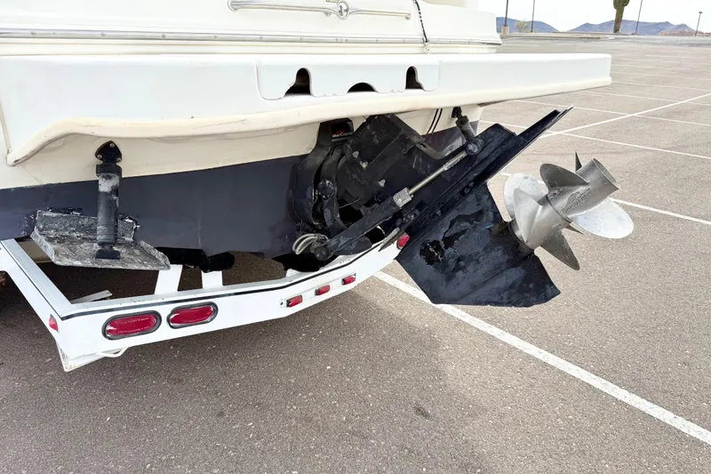 Slide: The Image of 1999 Sea Ray Sundancer 260 boat stern with propeller and trailer in parking lot. - 32