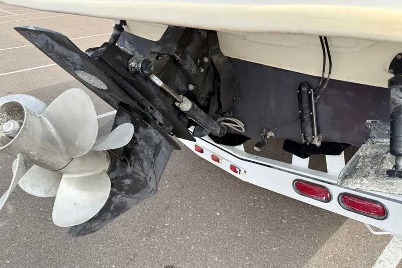Slide: The Image of 1999 Sea Ray Sundancer 260 boat stern with propeller and trailer in parking lot. - 33