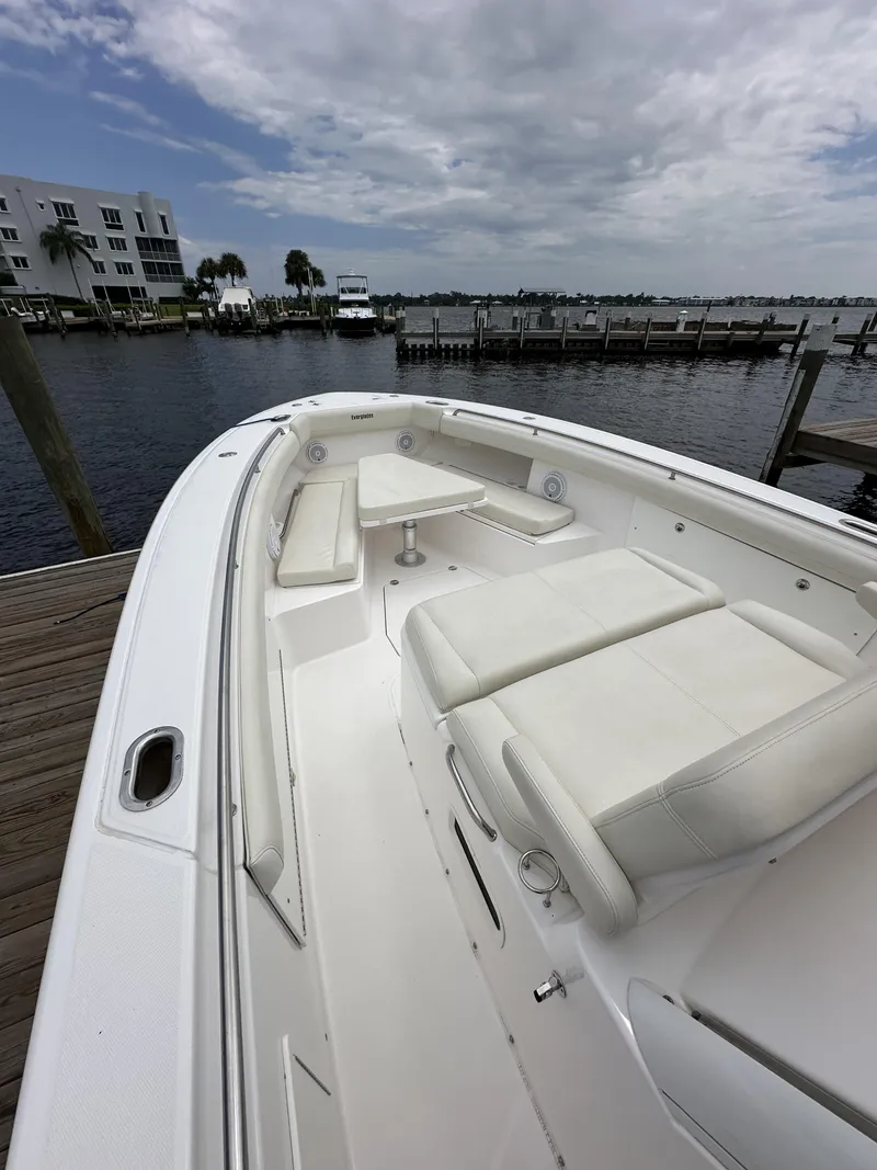 Slide: The Image of 2017 Everglades 435 Center Console boat docked by the waterfront under cloudy skies. - 20