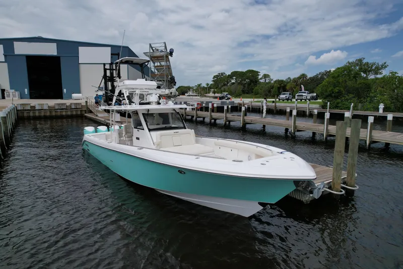 Slide: The Image of 2017 Everglades 435 Center Console boat docked at marina under cloudy sky. - 3