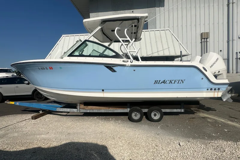 The Image of 2021 Blackfin 252 DC boat on trailer, light blue hull, parked outdoors. - 0