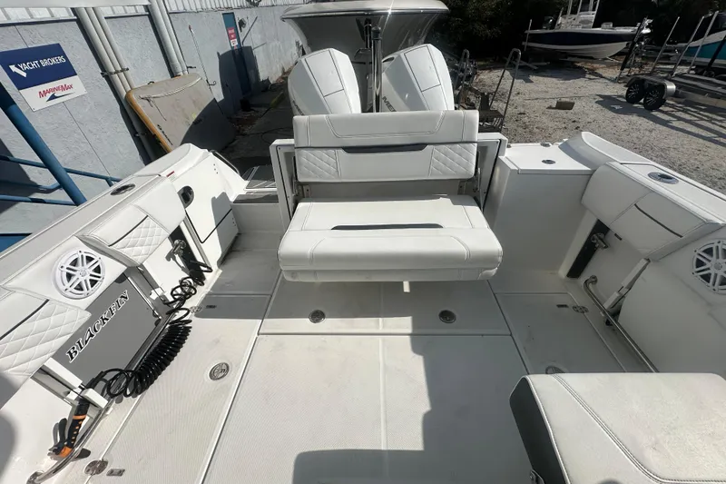 Slide: The Image of 2021 Blackfin 252 DC boat interior with white seating and marine speakers. - 12