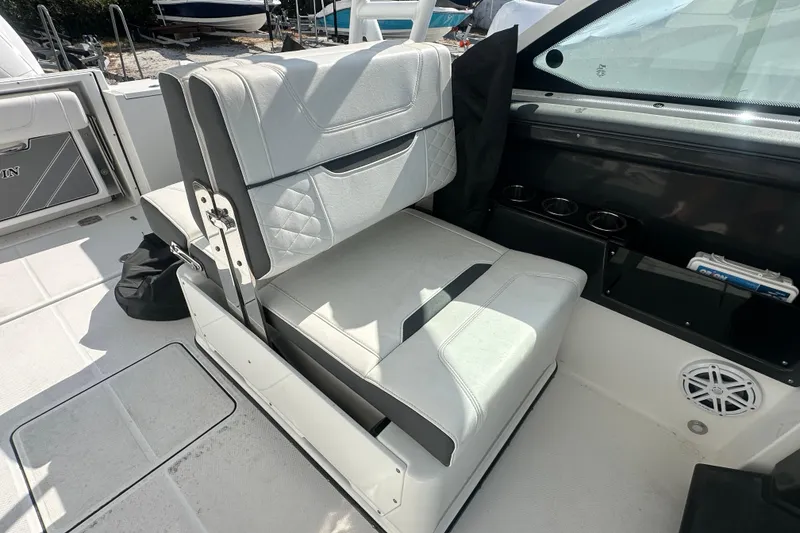 Slide: The Image of 2021 Blackfin 252 DC boat interior with white cushioned seating and cup holders. - 14