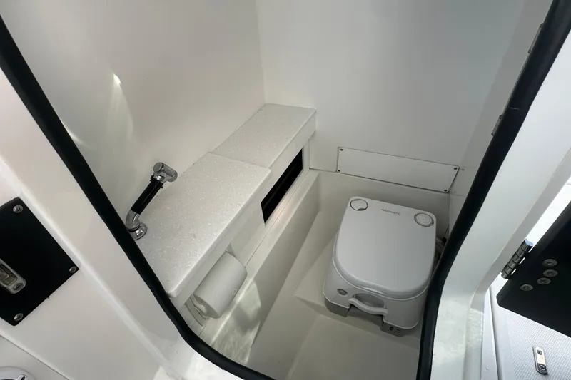 Slide: The Image of 2021 Blackfin 252 DC boat interior with compact marine toilet and storage. - 18