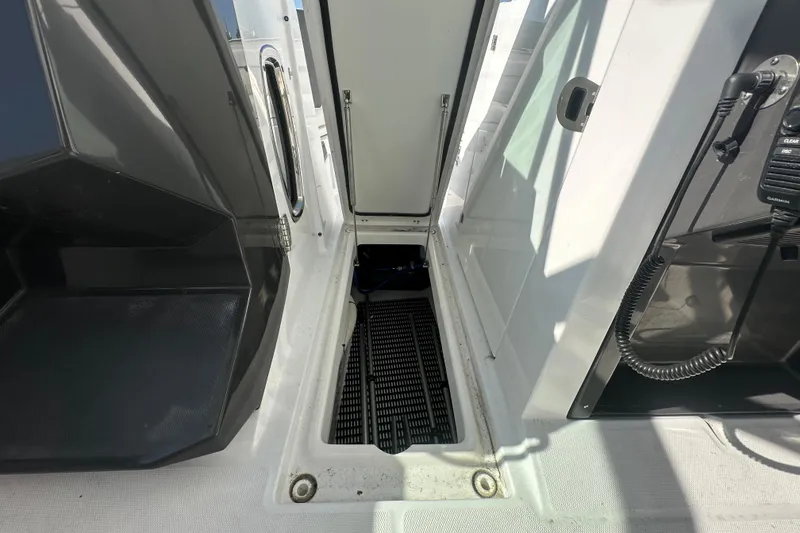 Slide: The Image of 2021 Blackfin 252 DC boat interior with open storage compartment and communication equipment. - 3