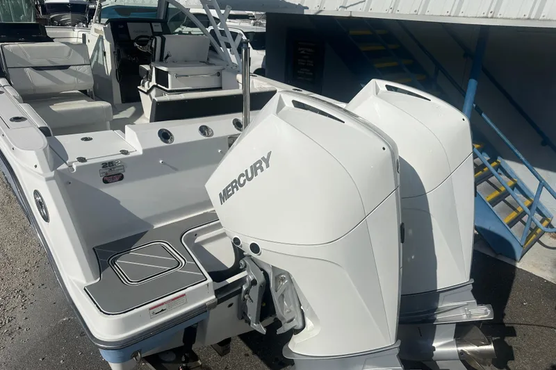 Slide: The Image of 2021 Blackfin 252 DC boat with dual Mercury outboard engines, docked near a staircase. - 5