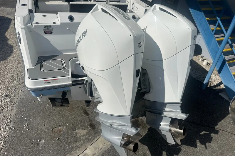 Slide: The Image of 2021 Blackfin 252 DC boat with dual Mercury outboard engines, docked on a sunny day. - 7