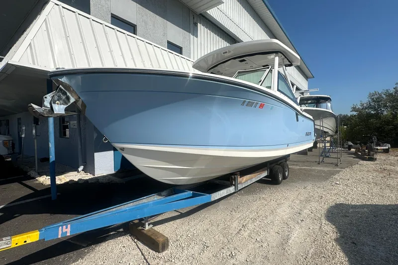 Slide: The Image of 2021 Blackfin 252 DC boat on trailer, light blue hull, parked outdoors. - 8