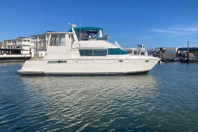 The Image of 1997 Carver 500 Cockpit Motor Yacht on calm water, dockside view. - 0