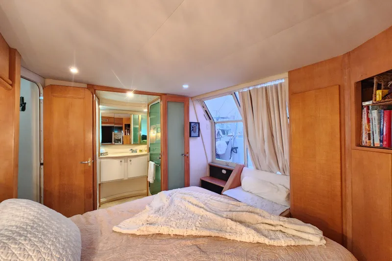 Slide: The Image of Luxurious bedroom interior of 1997 Carver 500 Cockpit Motor Yacht with cozy bedding and wooden accents. - 12