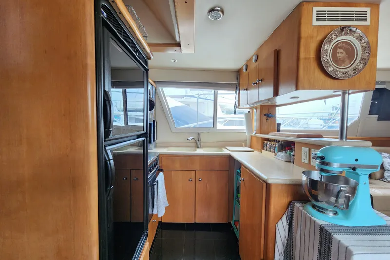 Slide: The Image of Interior of 1997 Carver 500 Cockpit Motor Yacht kitchen with wooden cabinets and appliances. - 15
