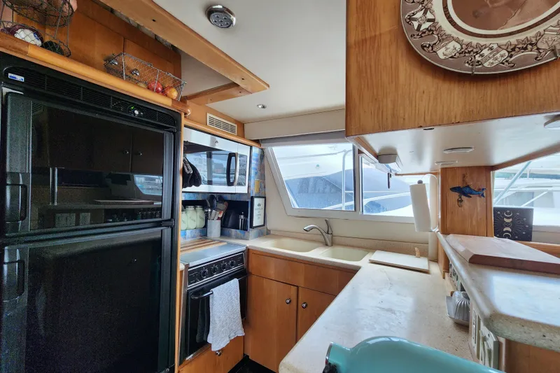 Slide: The Image of Interior of 1997 Carver 500 Cockpit Motor Yacht kitchen with appliances and wooden cabinetry. - 16