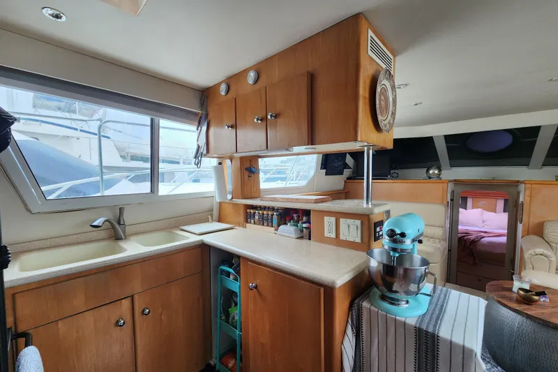Slide: The Image of Interior of 1997 Carver 500 Cockpit Motor Yacht kitchen with appliances and cozy seating area. - 17