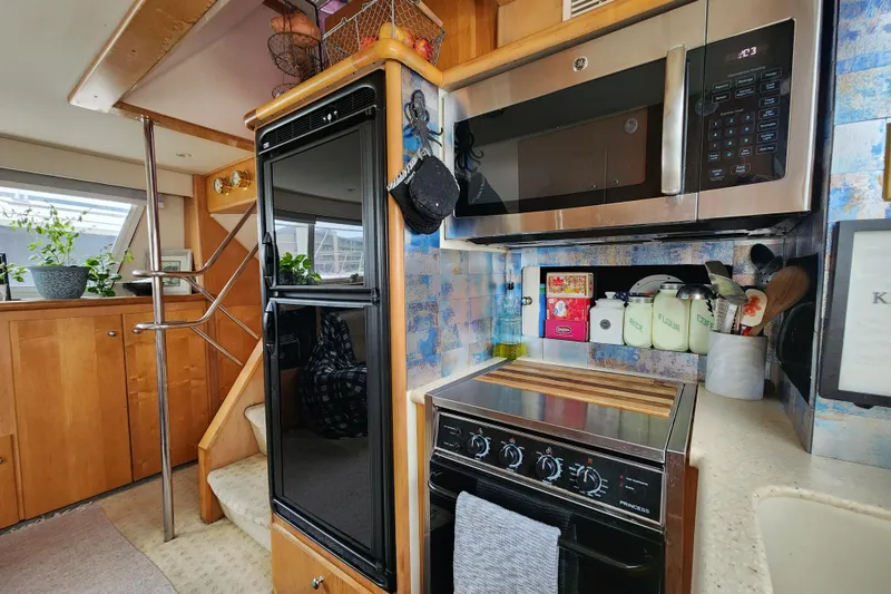 Slide: The Image of Interior of a 1997 Carver 500 Cockpit Motor Yacht kitchen with appliances and storage. - 18
