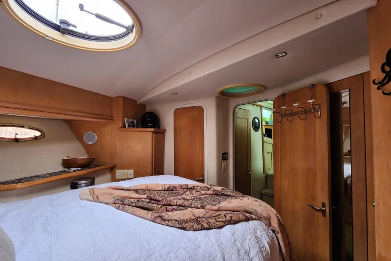 Slide: The Image of Interior of 1997 Carver 500 Cockpit Motor Yacht bedroom with cozy decor and wooden accents. - 7