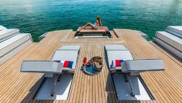 Slide: The Image of Luxury Evo Yachts 43 (2017) with sun loungers and a woman relaxing on deck. - 4