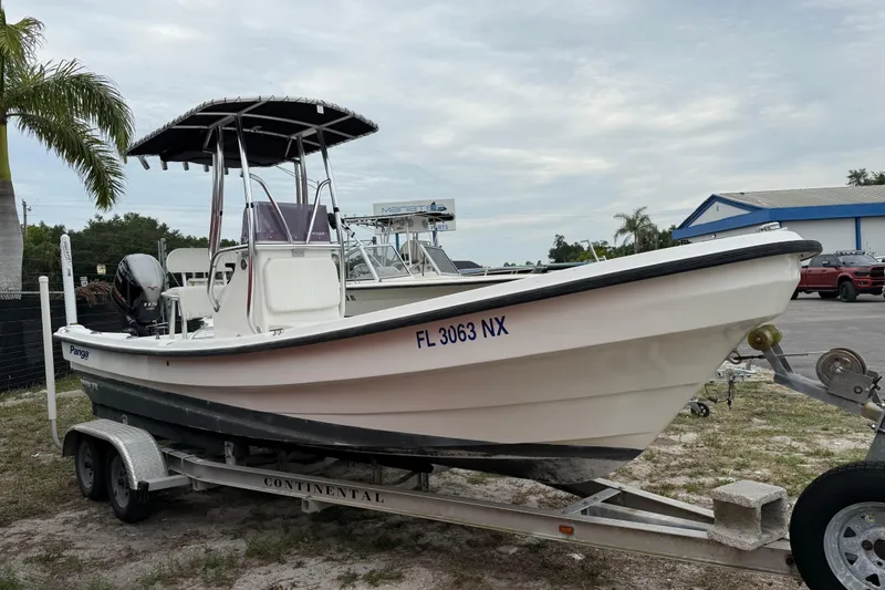 Slide: The Image of 2007 Panga 22LX boat on trailer, parked outdoors near palm trees and buildings. - 1
