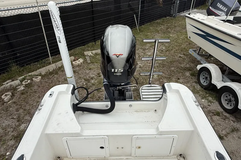 Slide: The Image of 2007 Panga 22LX boat with Yamaha 115 engine, docked on grass near a fence. - 11