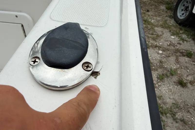 Slide: The Image of Close-up of a 2007 Panga 22LX boat showing a finger pointing at a damaged area. - 13