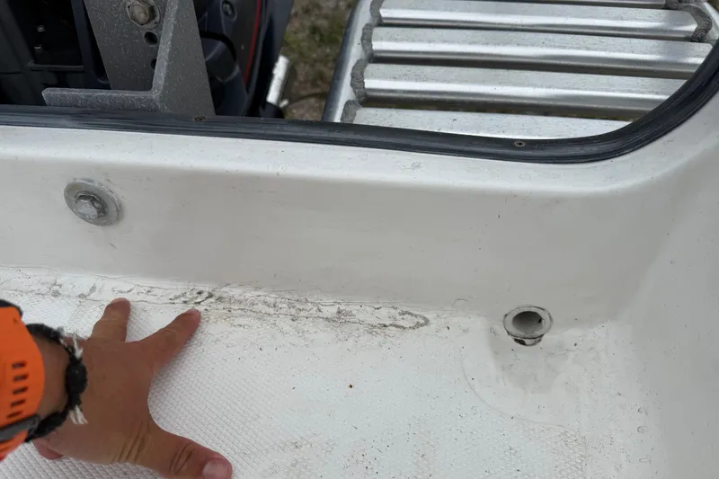 Slide: The Image of Close-up of a 2007 Panga 22LX boat interior showing hand and drainage area. - 15