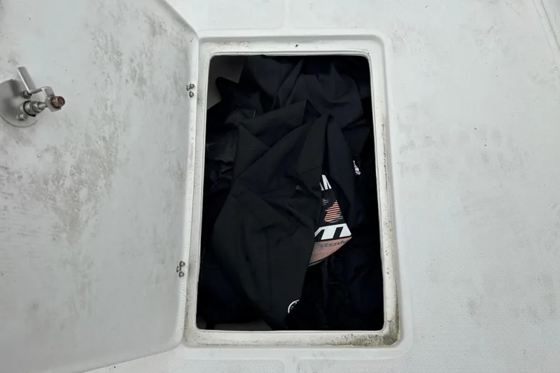 Slide: The Image of Open storage compartment on a 2007 Panga 22LX boat, containing black fabric items. - 32