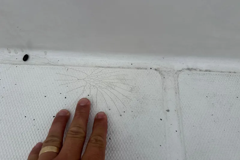 Slide: The Image of Hand inspecting crack on 2007 Panga 22LX boat surface. - 34
