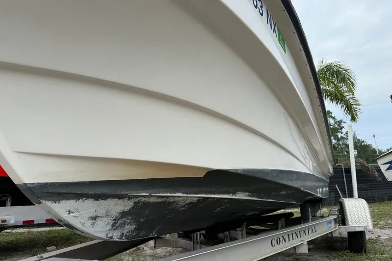 Slide: The Image of 2007 Panga 22LX boat on trailer, side view with palm tree background. - 9