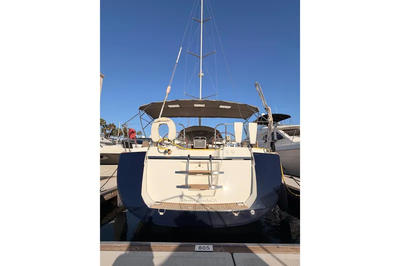 Slide: The Image of 2013 Jeanneau 57 yacht docked at marina, rear view with clear blue sky. - 10