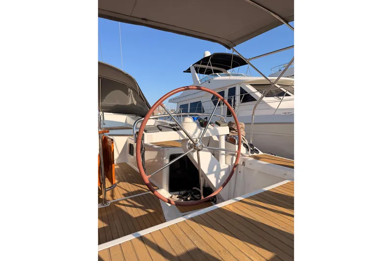 Slide: The Image of 2013 Jeanneau 57 yacht helm with wooden deck and steering wheel. - 19